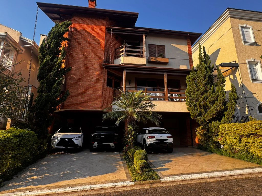 Fachada da casa, com varanda e vagas de garagem cobertas