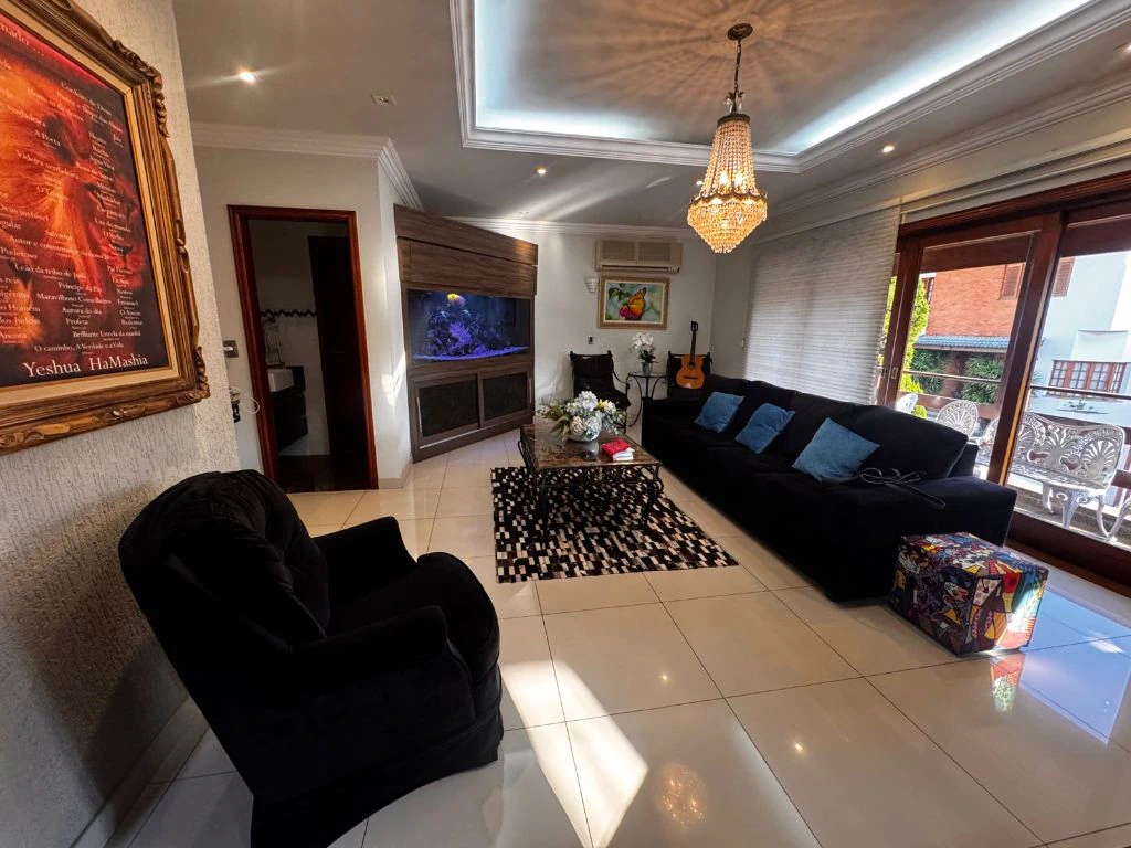 Outro ângulo da sala de estar, com lustre de cristal e espelho decorativo