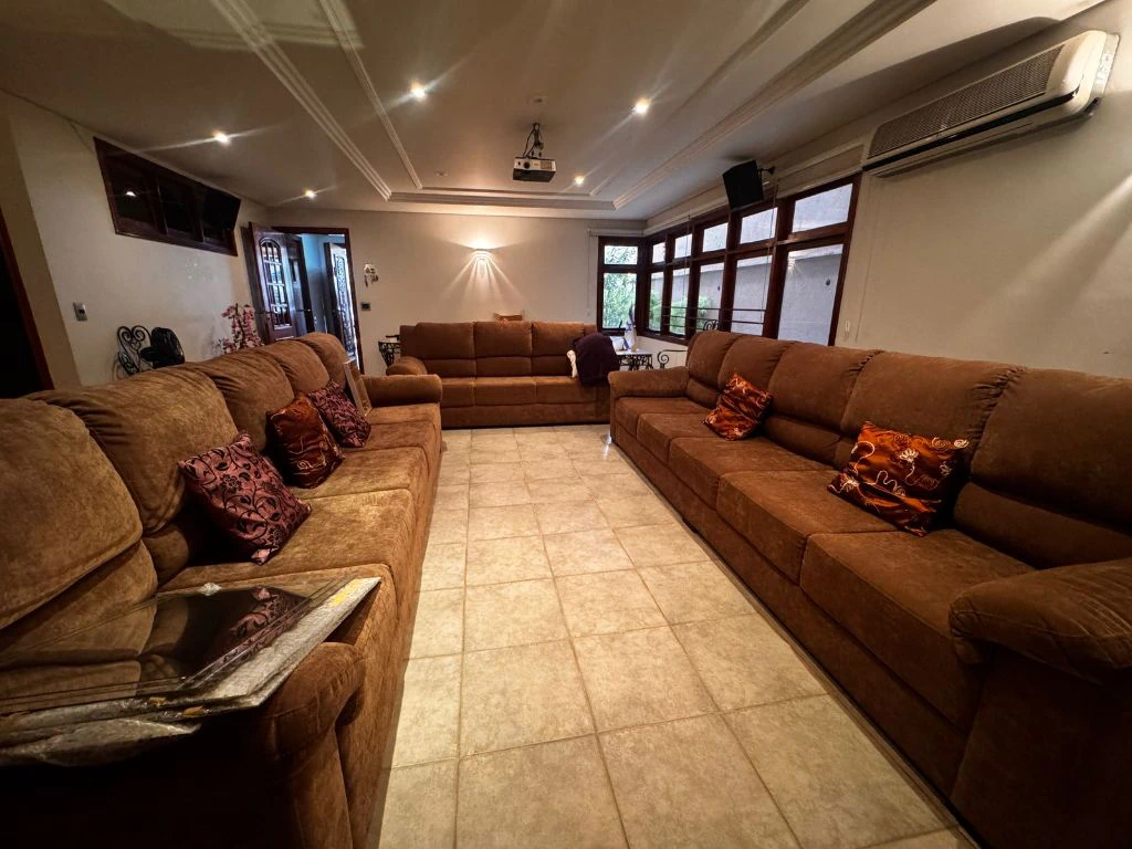 Sala de estar ampla, com três conjuntos de sofás